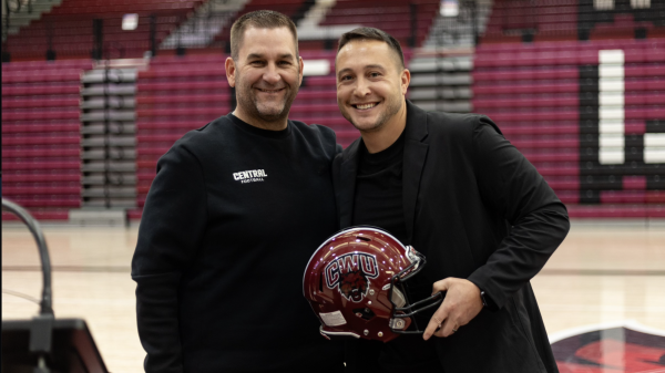 Nolan Teasley posing with his college helmet from Central Washington University